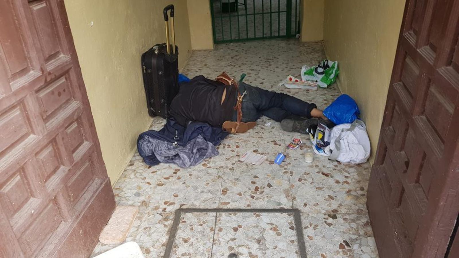 Un hombre duerme en un portal.