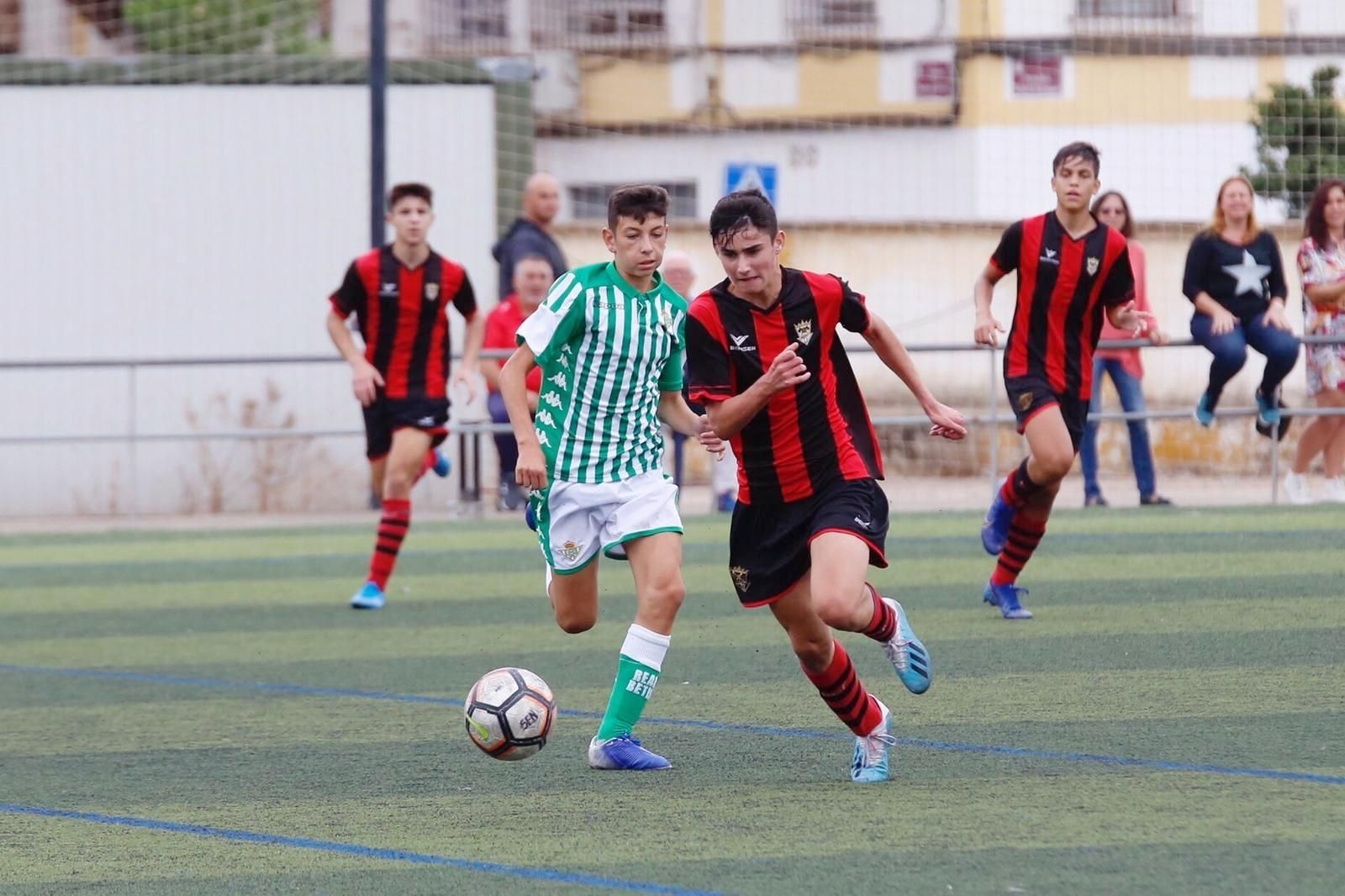 Un jugador del Séneca pugna con uno del Betis por hacerse con el balón.