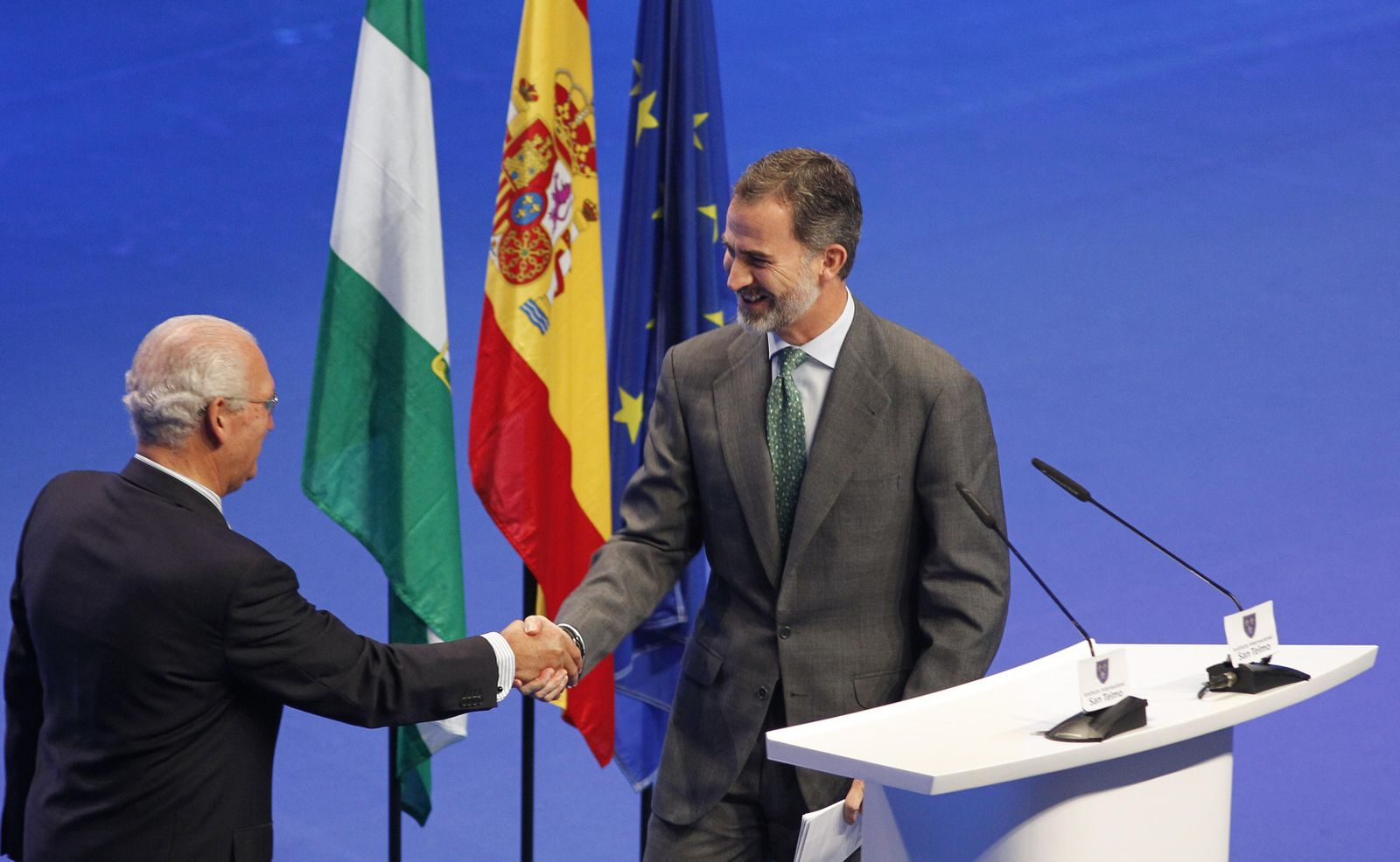 El Rey saluda a Eustasio Cobreros, presidente de la Fundación San Telmo, al subir al escenario para pronunciar su discurso, ayer en Sevilla.