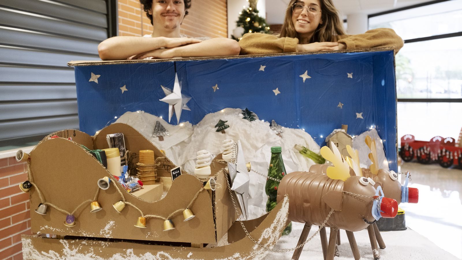 Dos de los jóvenes universitarios junto a su propuesta decorativa.