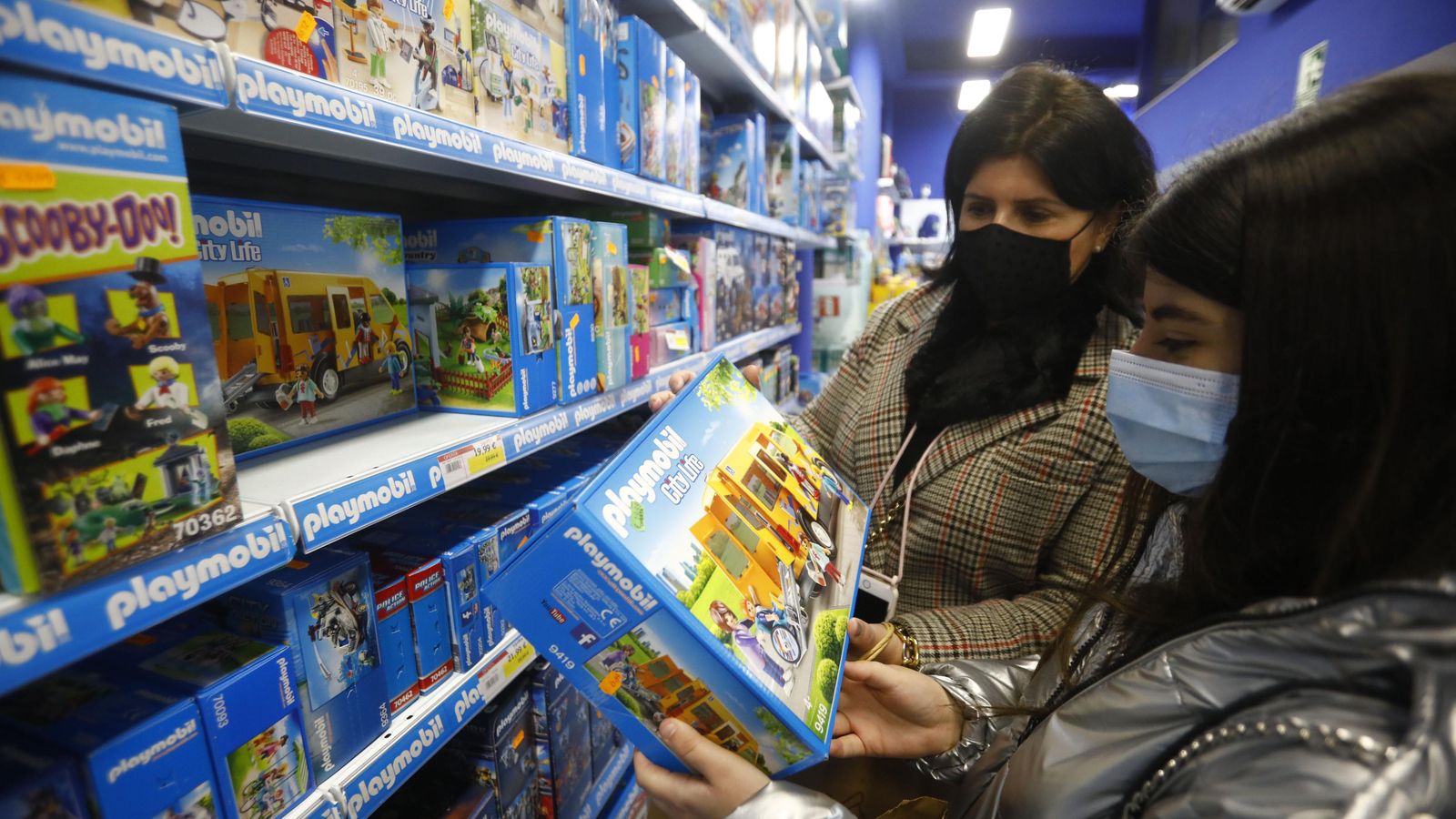 Dos mujeres escogen juguetes de Playmobil en una tienda.