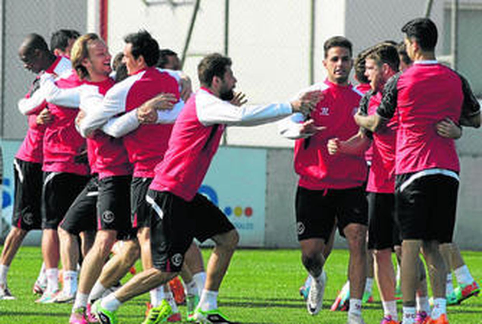 Varios jugadores del Sevilla se abrazan durante uno de los juegos que se pudieron ver en los 15 minutos que Emery abrió las puertas del entrenamiento.