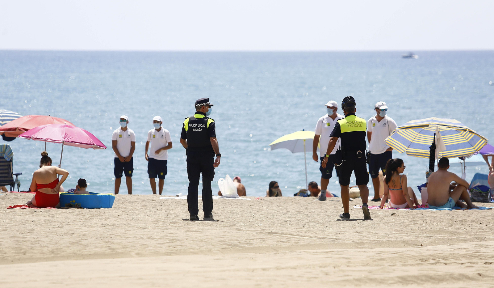 Agentes de la Policía Local y vigilantes, en una playa de Málaga.