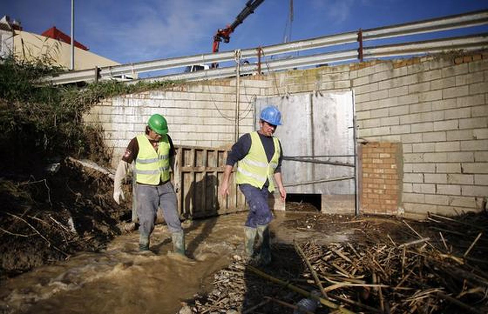 Los trabajadores refuerzan la compuerta para evitar nuevas inundaciones en Écija ante la previsión de lluvias.

Foto: Antonio Pizarro