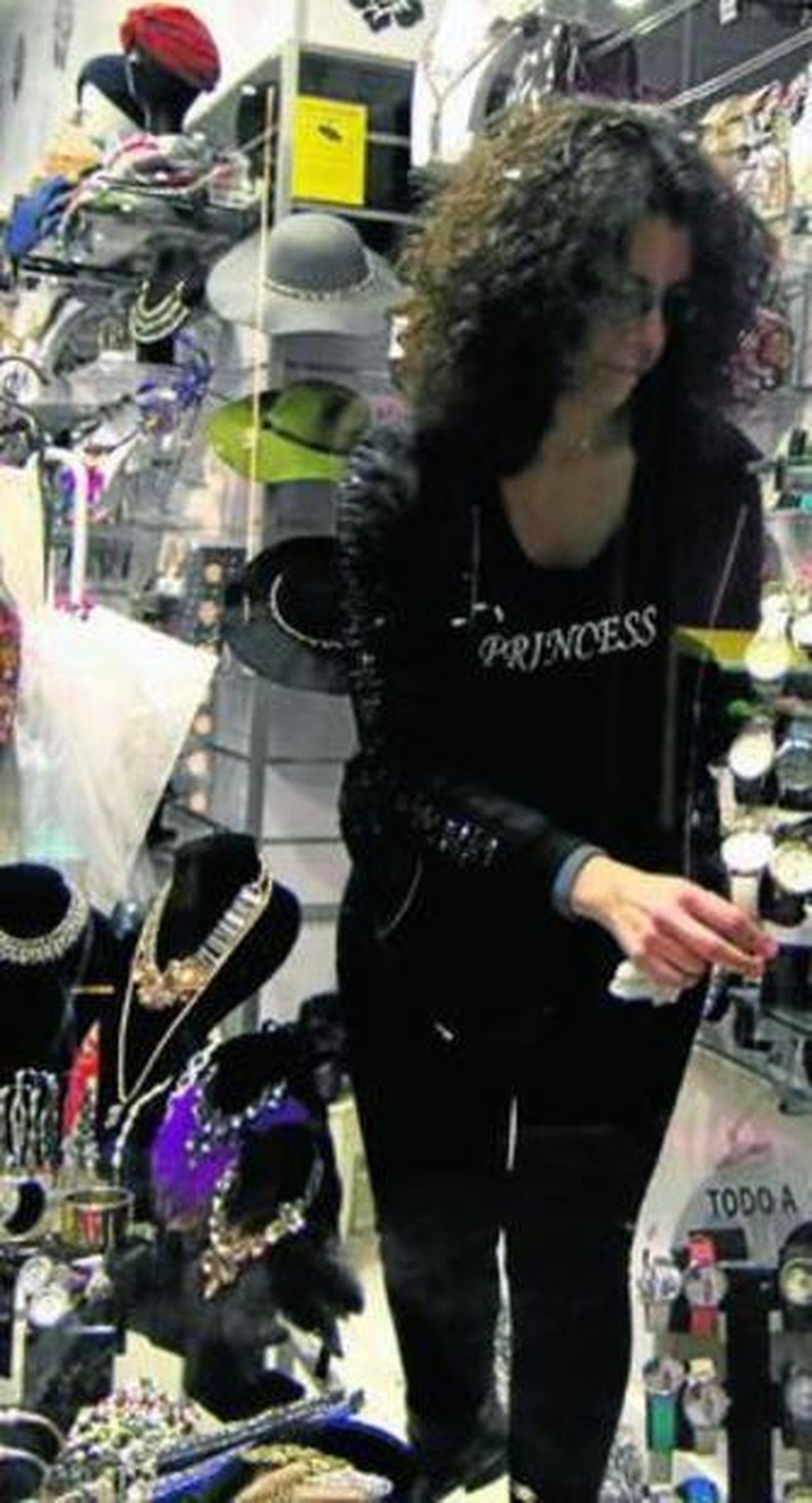 Una dependienta arregla un escaparate en una tienda del centro.