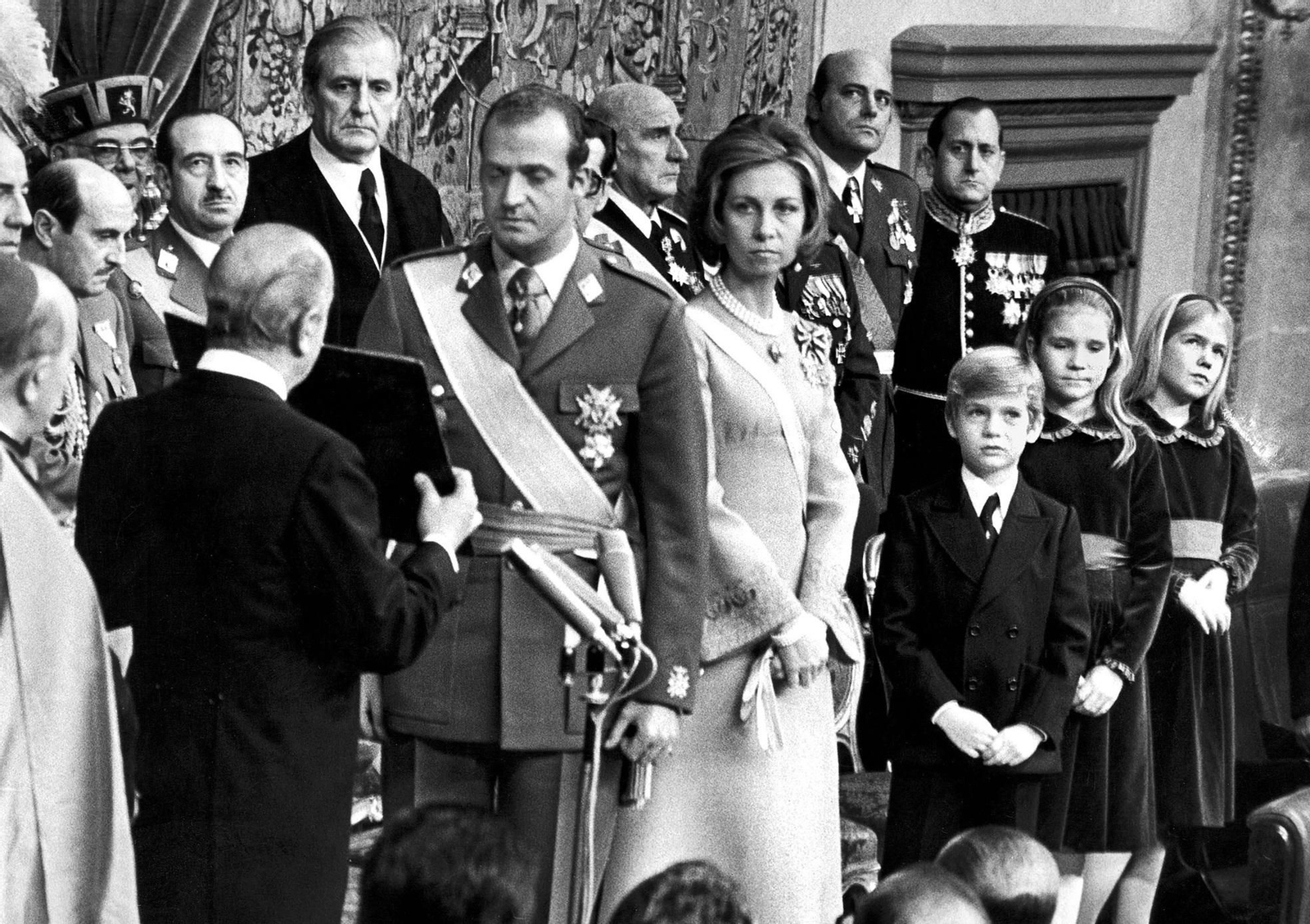 Juan Carlos presta juramento como Rey ante el presidente de las Cortes franquistas, Alejandro Rodíguez de Valcárcel (de espaldas). Es el 22 de noviembre de 1975.