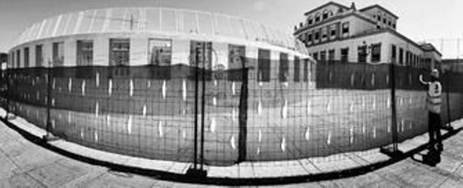 Un obrero revisa el vallado de las pistas deportivas del colegio La Salle Mirandilla.