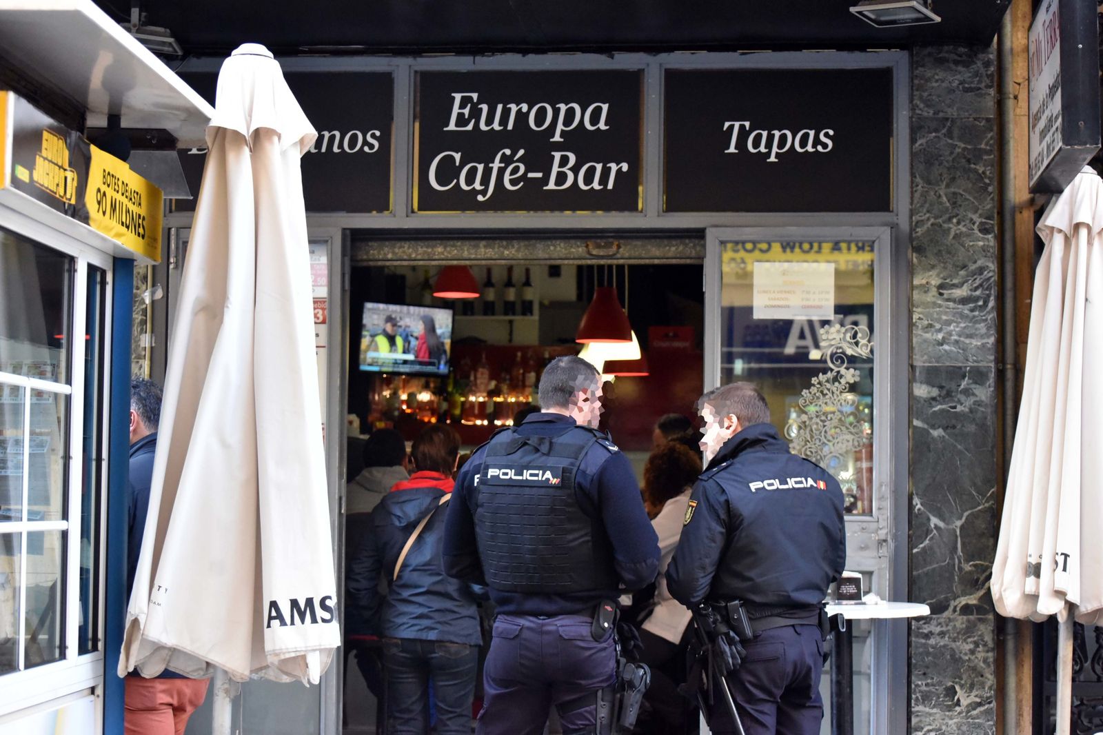 Dos agentes de Policía, ante el establecimiento, momentos después de la agresión.