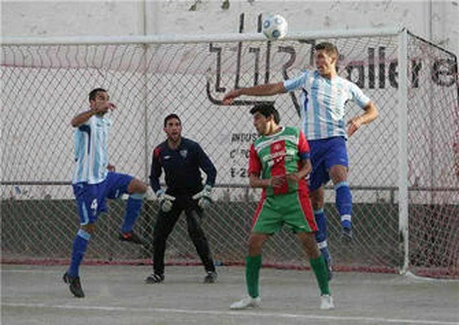 Jona despeja de cabeza ante la oposición de Basti y la mirada de su compañero Omar.