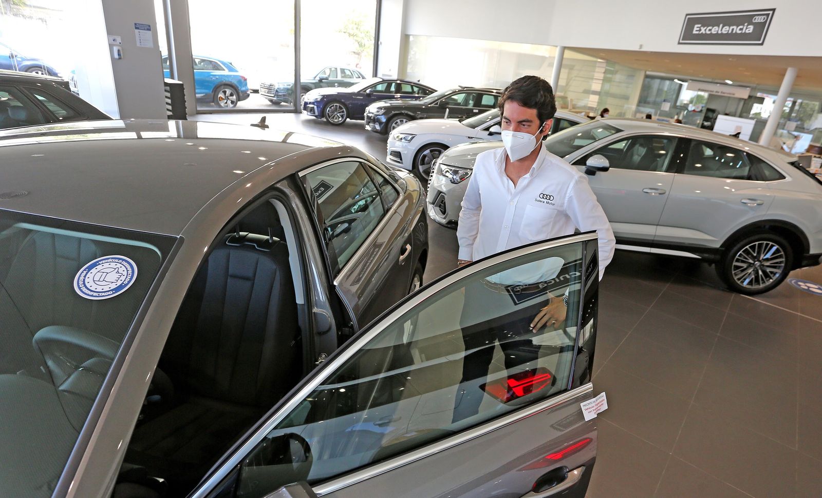 Un hombre observa un coche en un concesionario.