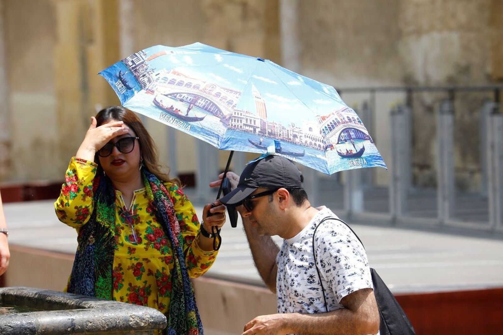 Una pareja se refresca en una fuente.