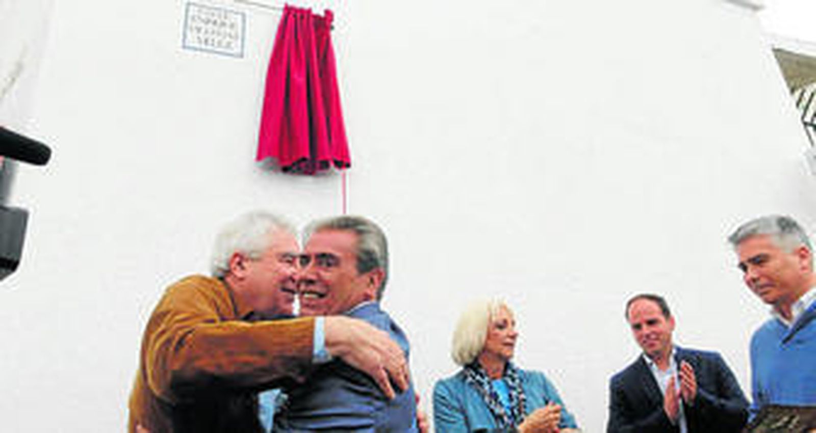 Eugenio Mariscal, presidente del Aula de Cultura del Carnaval, abraza a Paco Villegas después de descubrirse el rótulo de la calle Enrique Villegas.