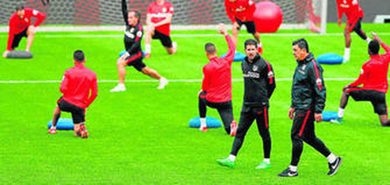El entrenador del Atlético, Diego Simeone, y su ayudante, Germán Burgos, dialogan durante un entrenamiento.