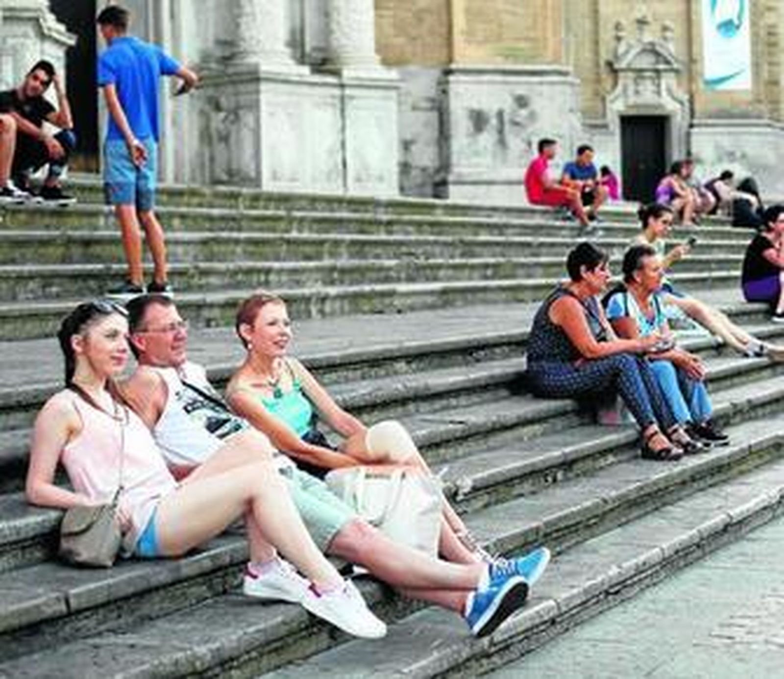 Veraneantes apostados en las escalinatas de la Catedral de Cádiz.