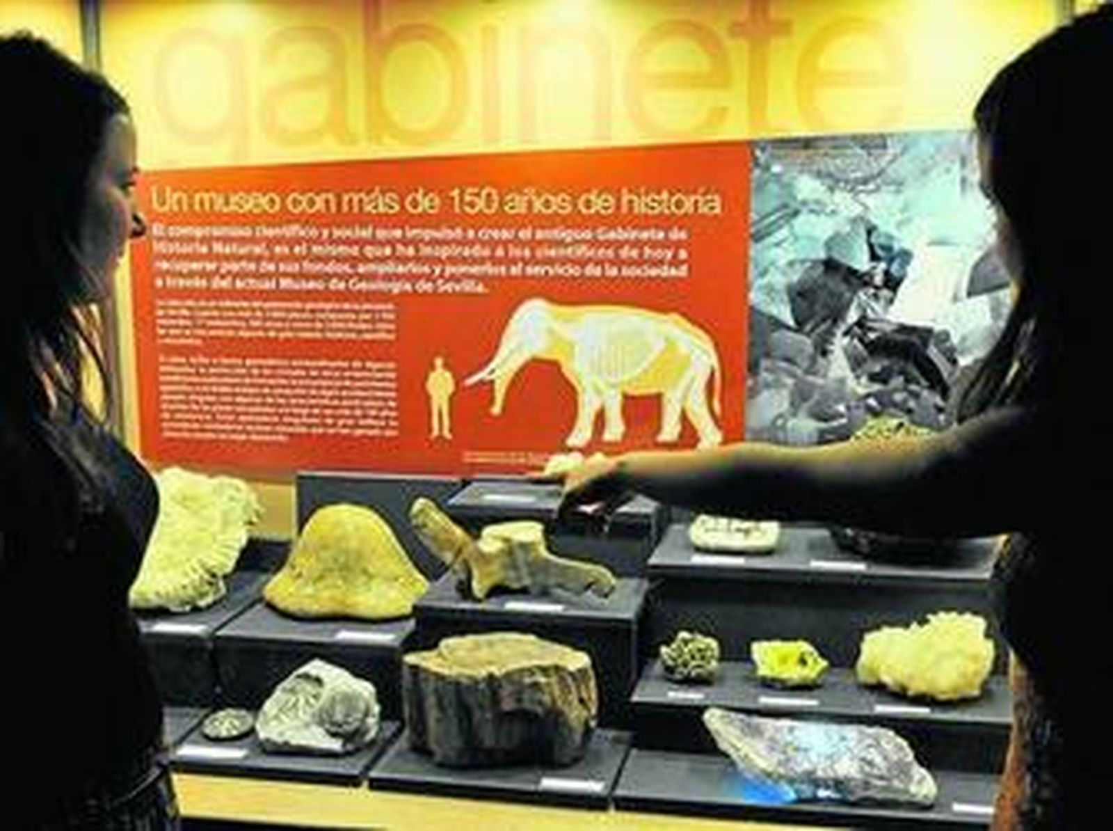 1. Dos jóvenes observan una de las vitrinas de la exposición sobre historia geológica. 2. En el planetario, un grupo de escolares, tumbados en los 'puffs' de la sala, disfruta junto a sus docentes de las explicaciones sobre planetas.