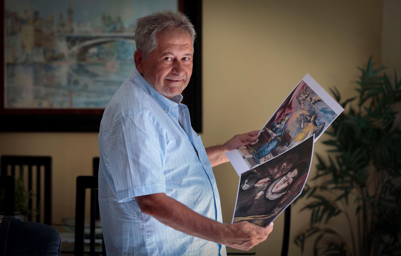 Juan Carlos Arias posa con unas láminas de cuadros que pudieron ser pintados por el falsificador Eduardo Olaya.