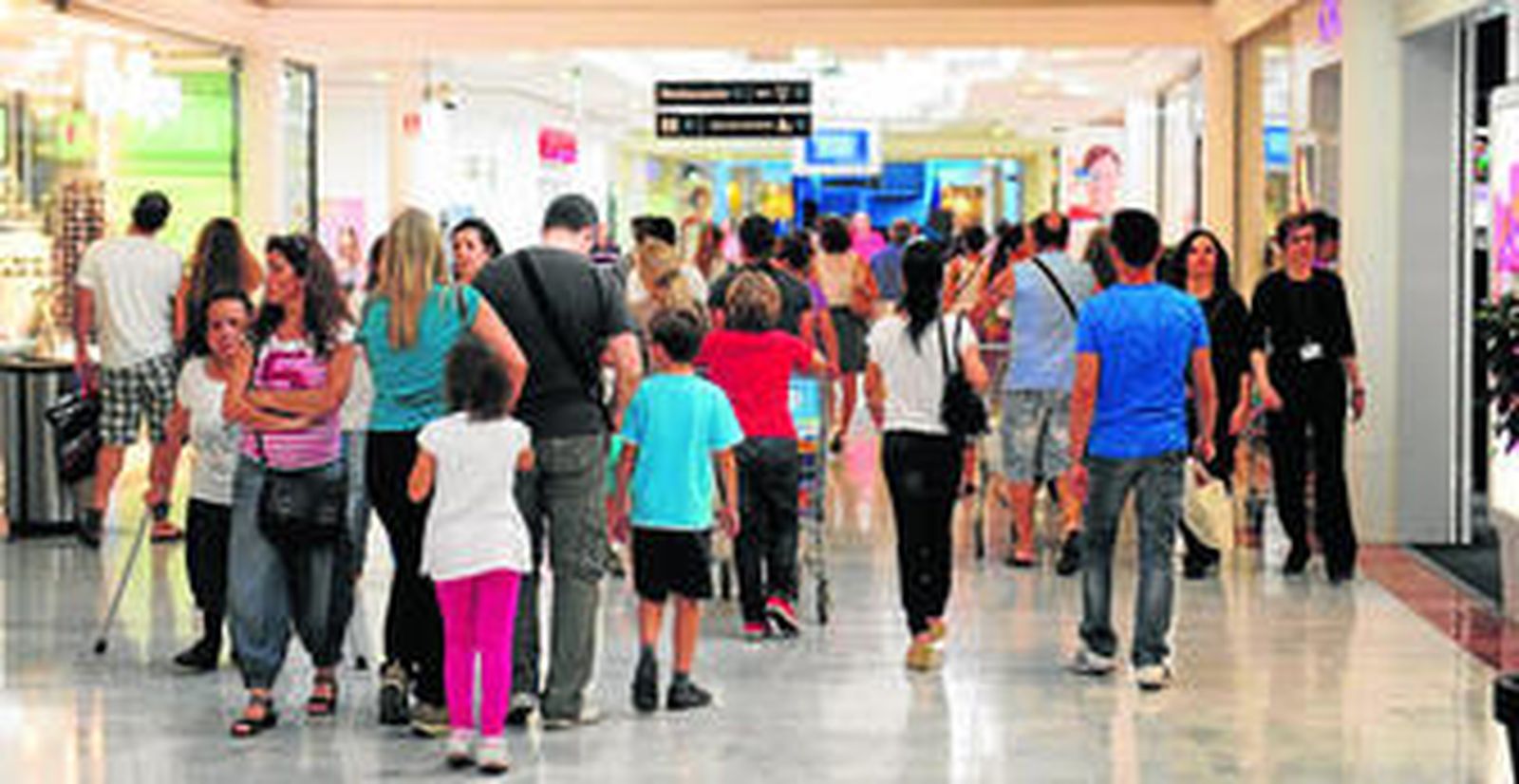 1. Uno de los pasillos de las galerías comerciales de Bahía Sur, con clientes de todas las edades paseando el pasado jueves.  2. Una joven, con bolsas en el brazo y sus tickets de compra, espera para rellenar las tarjetas de participación para el sorteo de tarjetas regalo, una de las iniciativas preparadas por el centro comercial. 3. Un comprador habitual de esta gran superficie sale con su carro repleto de productos del supermercado. 4. Un grupo de mujeres, sentadas en la zona de la terraza que da a la Bahía. (fotos: elías pimentel)