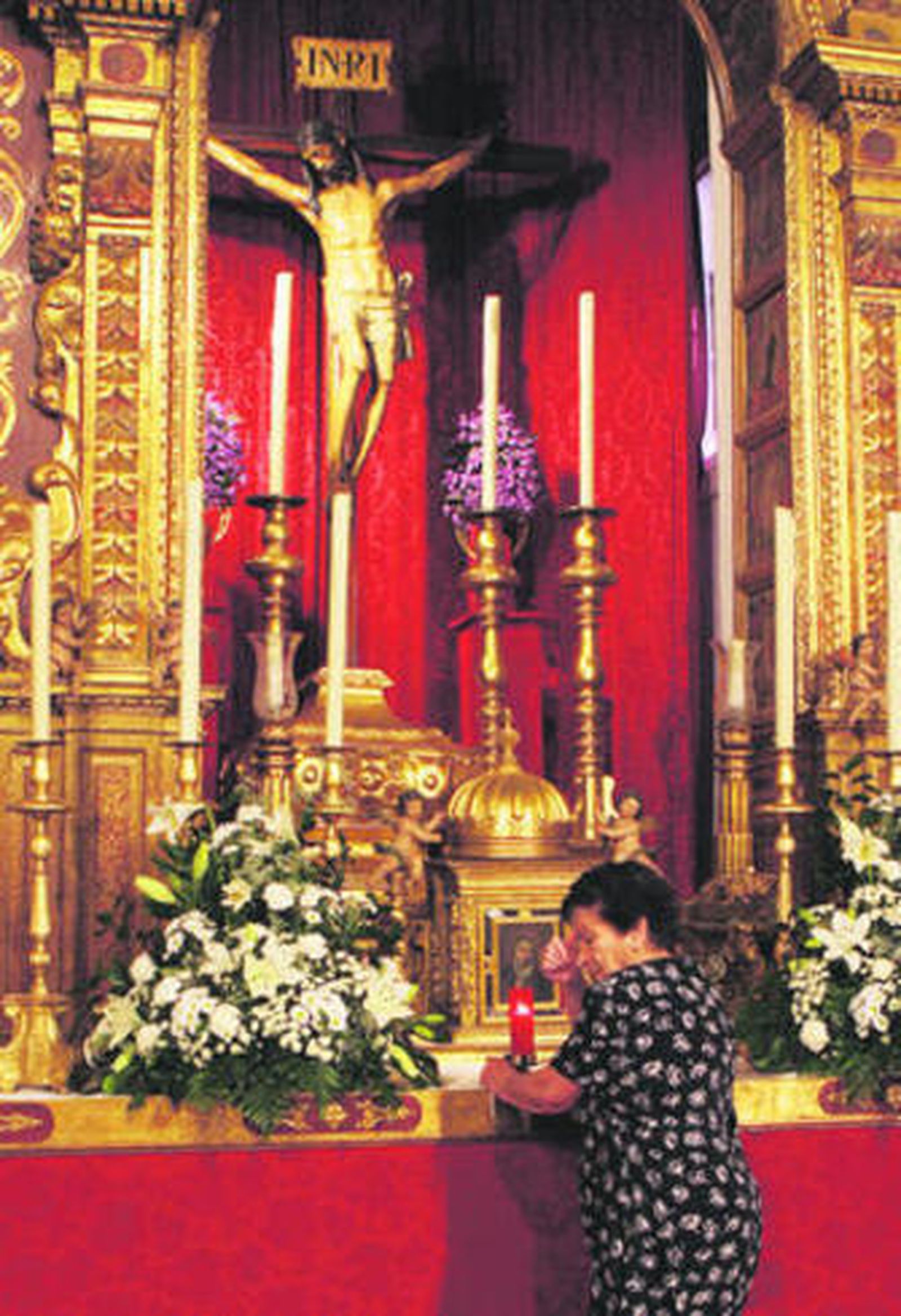 La ermitaña Josefa Muñoz se persigna ante el sagrario, a los pies del Cristo de la Vera-Cruz.