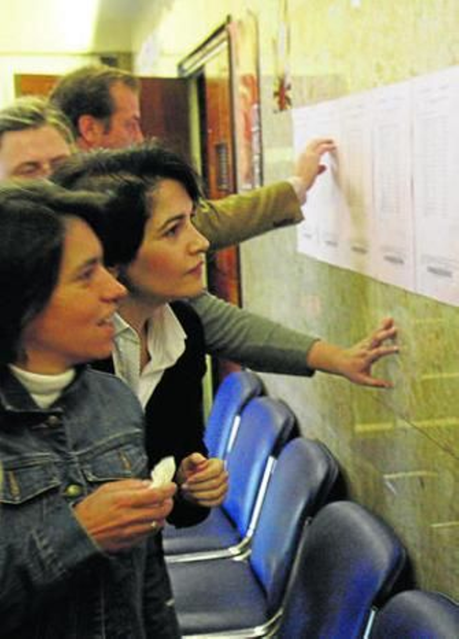 Familias comprobando la lista de admitidos en una imagen de archivo.