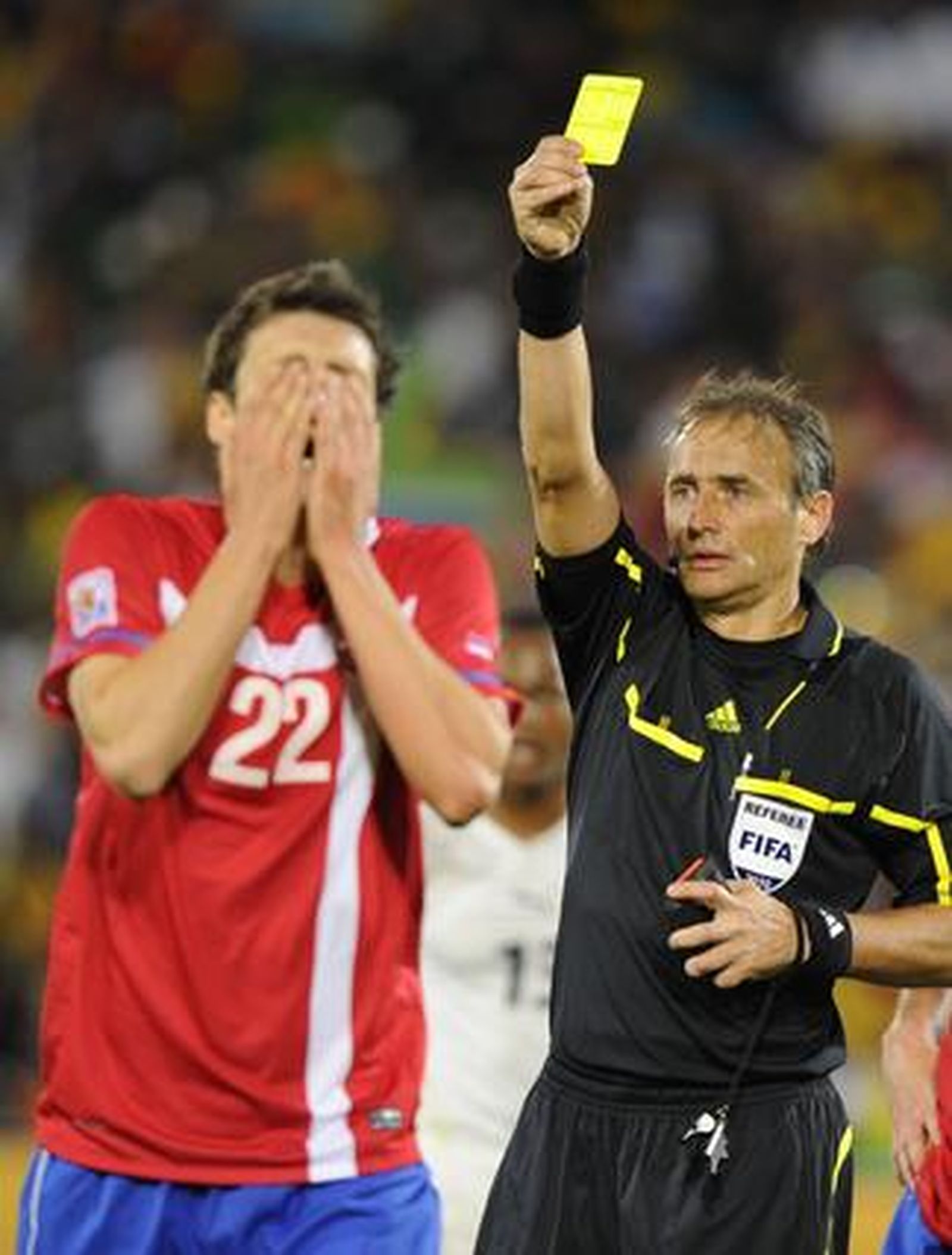 Kuzmanovic ve la tarjeta amarilla tras provocar el penalti con la mano. / AFP