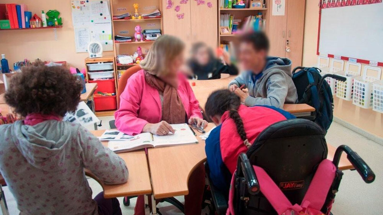 Una maestra atiende a varios alumnos del Colegio Arco Auxilia.