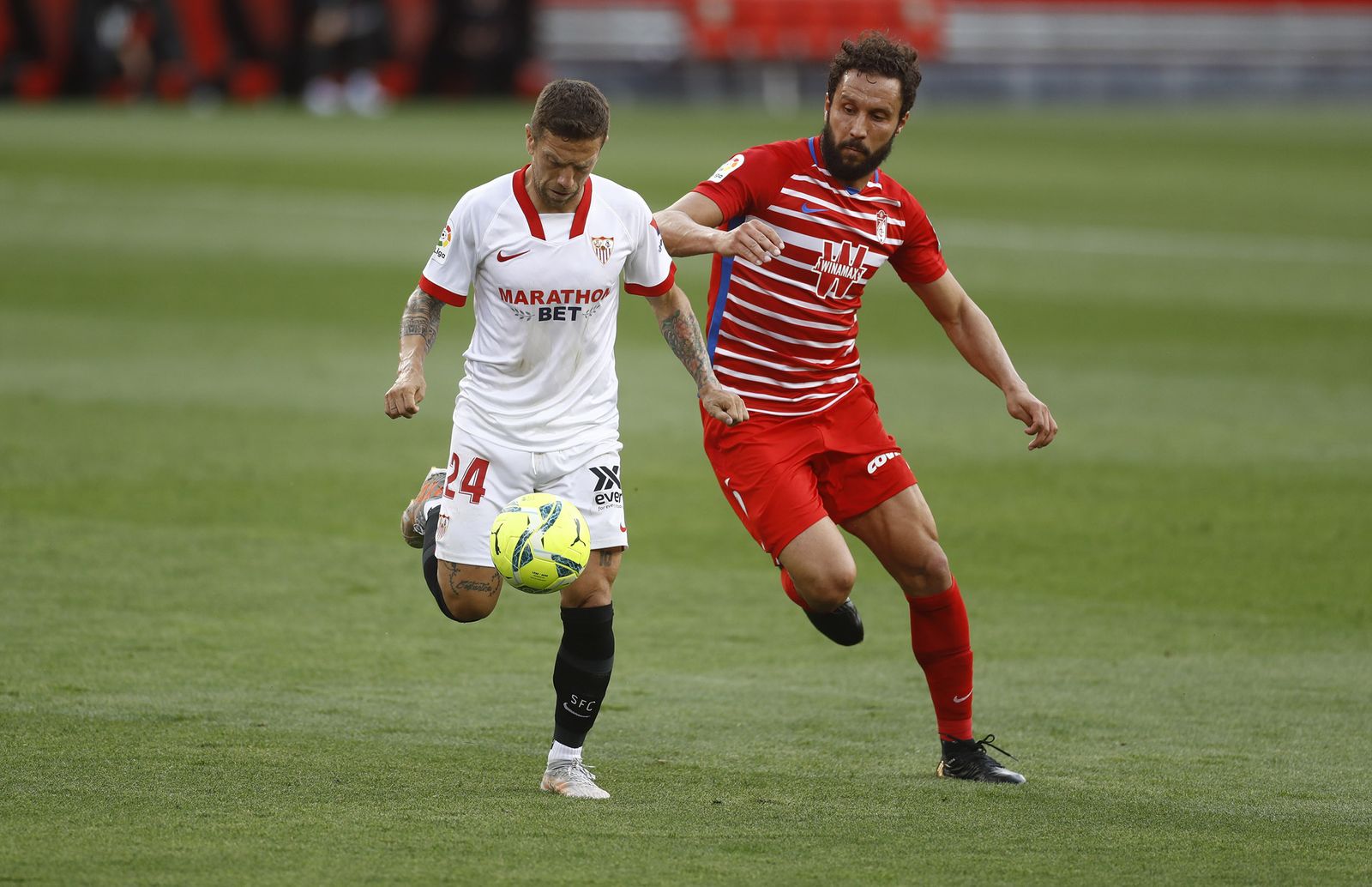Papu Gómez se dispone a tocar la pelota ante el acoso del central Germán.