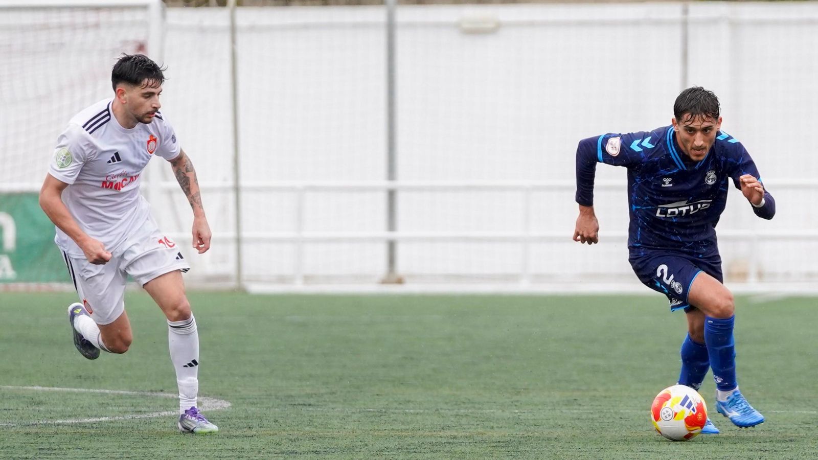 Chey avanza con el balón, perseguido por el local Manu