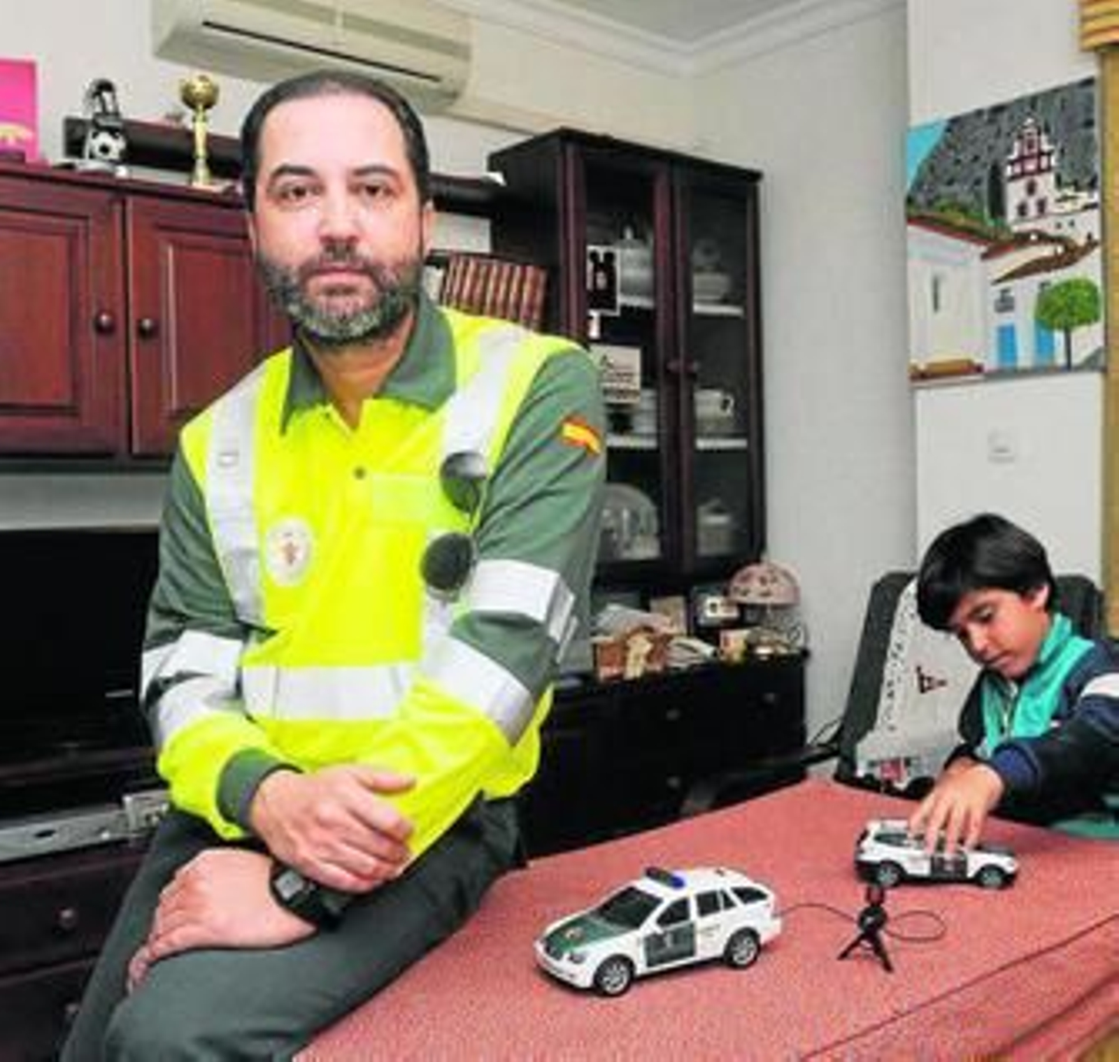 El agente Santamaría, en su casa ayer tarde;  al lado, su hijo, jugando con un coche de la Guardia Civil.