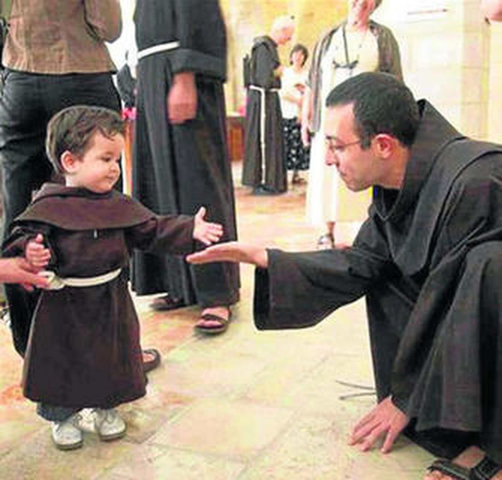 Un pequeño vestido de san Francisco ante un franciscano en una fiesta de 'Holywins'.