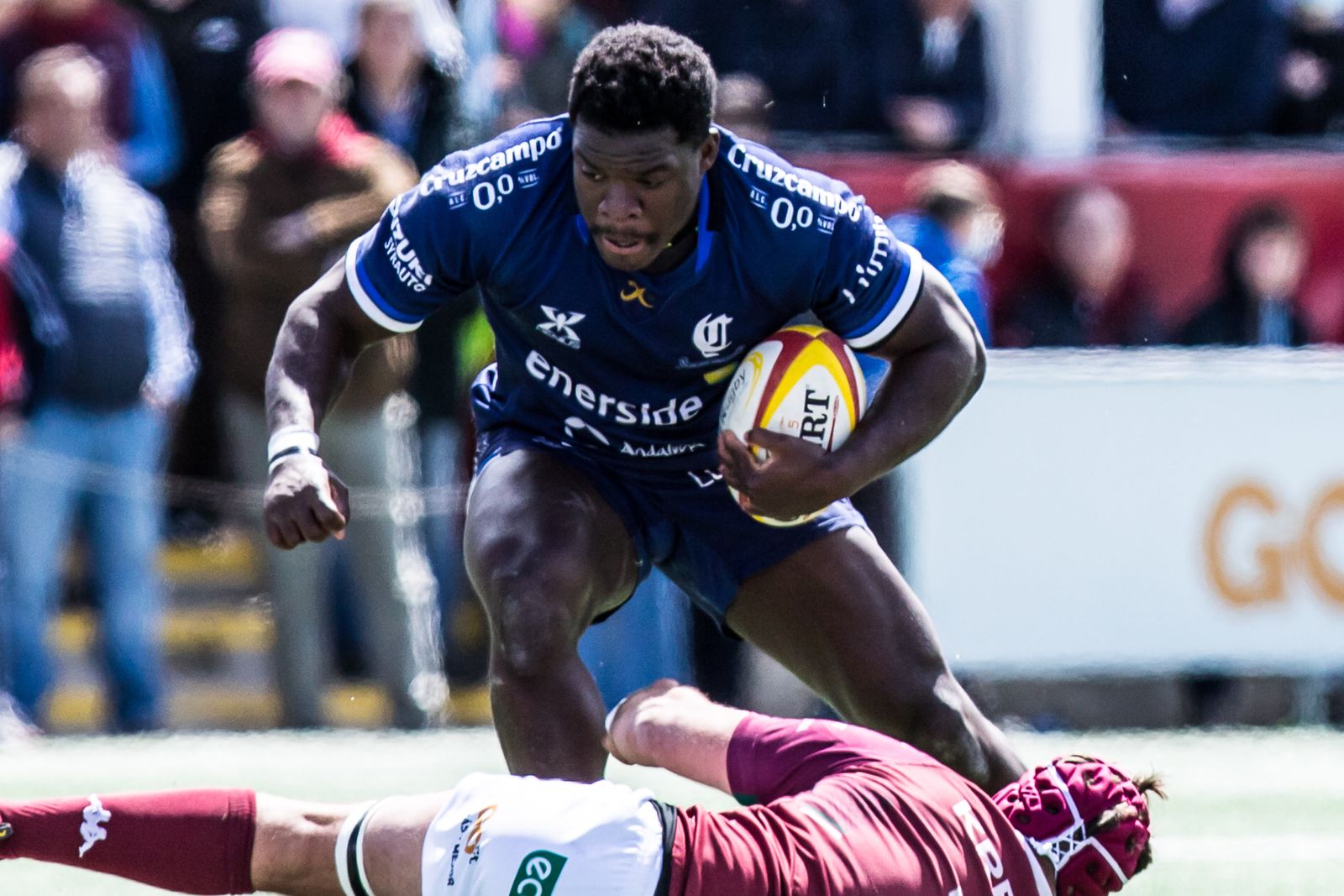 Manolo Bobo intentando escaparse de un rival con el balón en las manos.