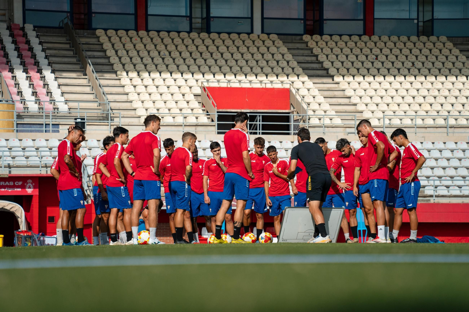 La plantilla del Algeciras atiende las explicaciones de Javi Vázquez durante un entrenamiento.