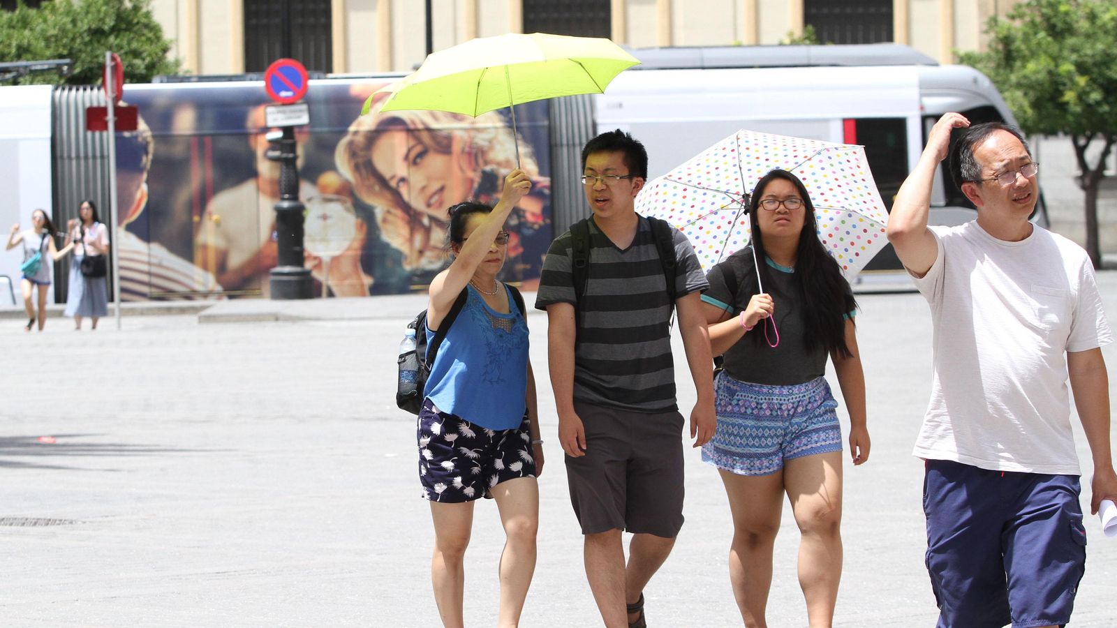 Un grupo de turistas se cubren del sol en el centro de Sevilla