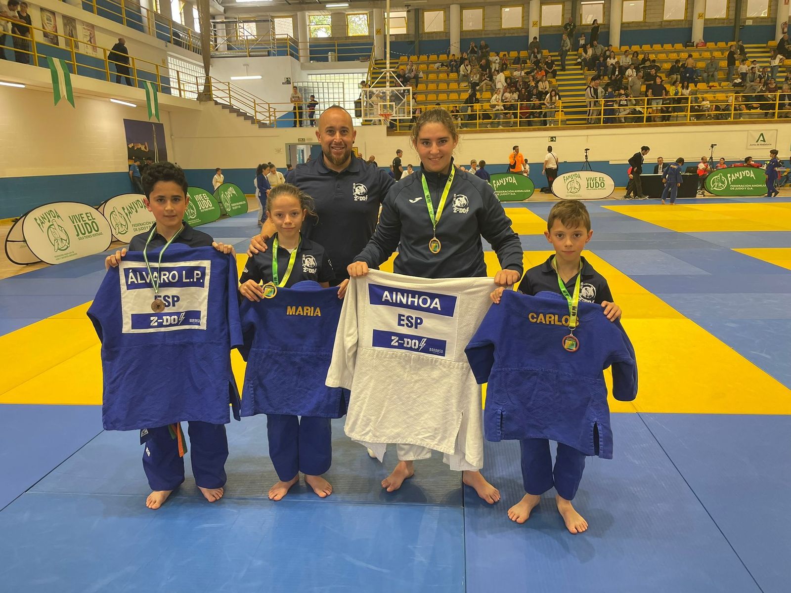 Los jóvenes deportistas junto a su entrenador.
