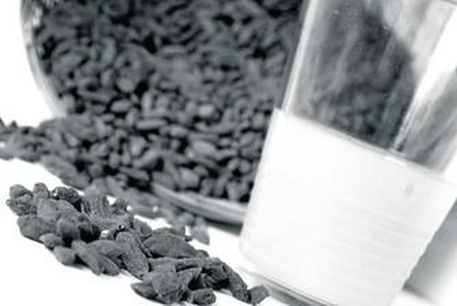 Una cesta con bayas de Goji junto a un vaso de zumo de naranja.