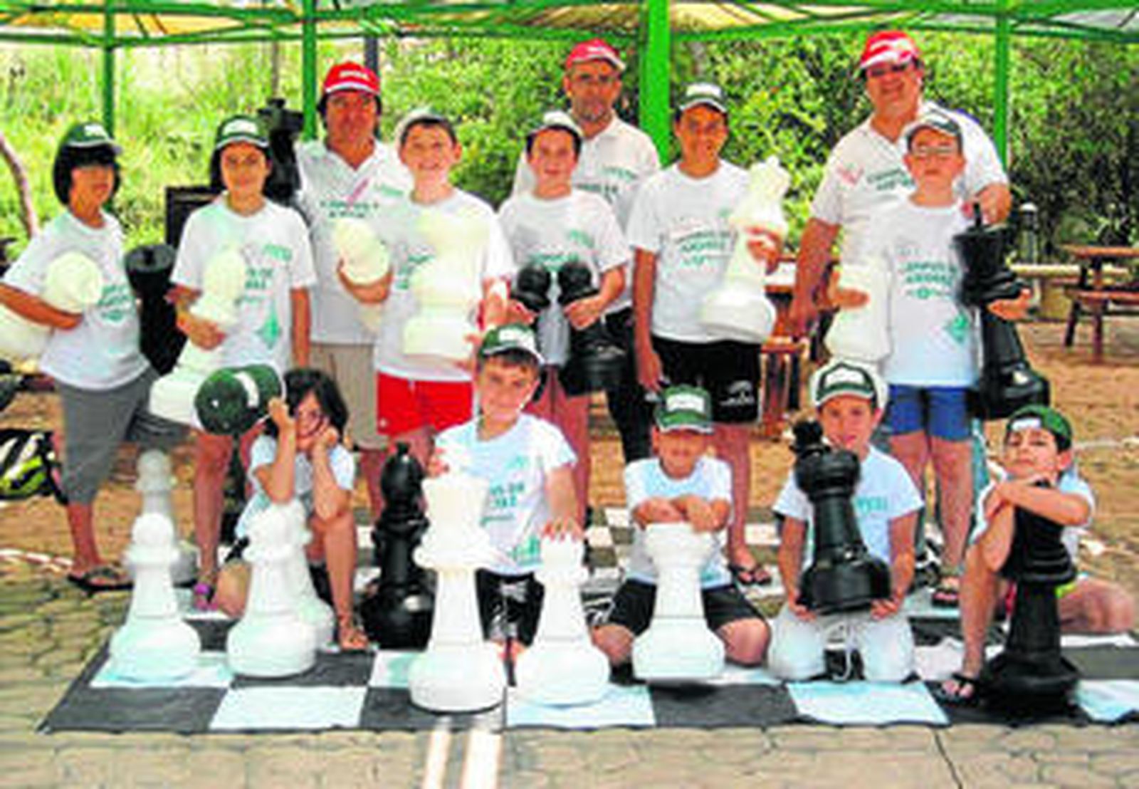 Niños y monitores posan en el campus de ajedrez que se celebra en Isla Mágica.