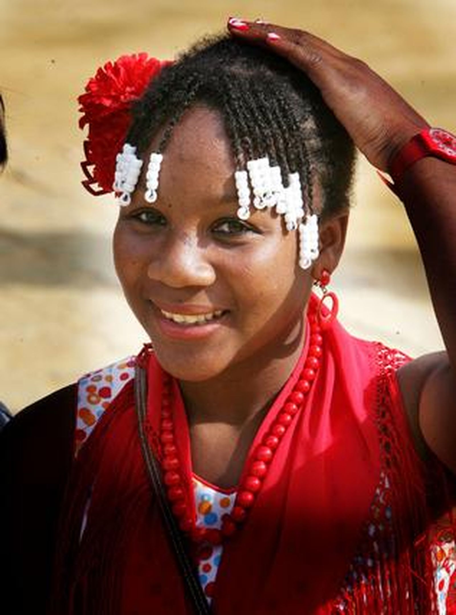 Una joven luce su traje de flamenca con un atrevido peinado en que el blanco del flequillo contrasta con los adornos rojos.

Foto: Pascual
