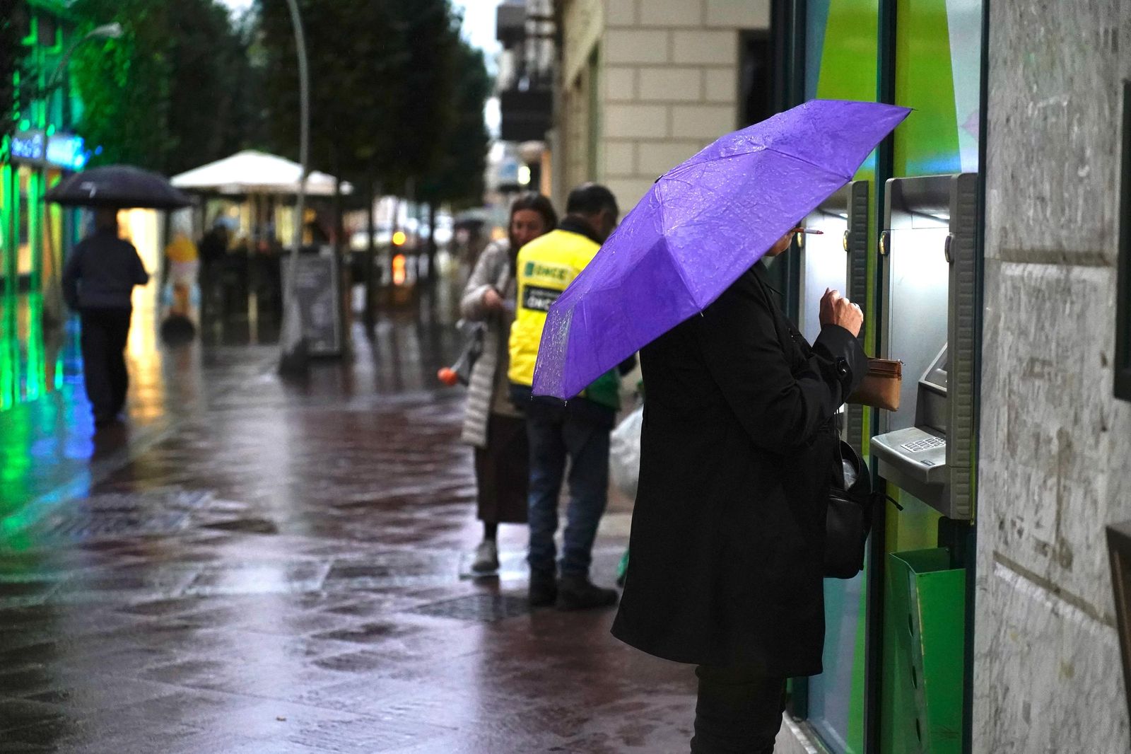 Personas con paraguas, en la calle Ancha de Algeciras.