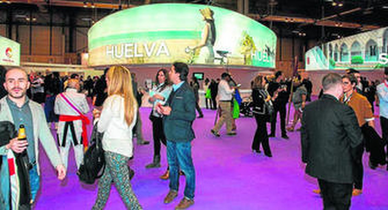 Un grupo de personas pasa delante del expositor de Huelva durante la pasada edición de la Feria internacional de turismo.