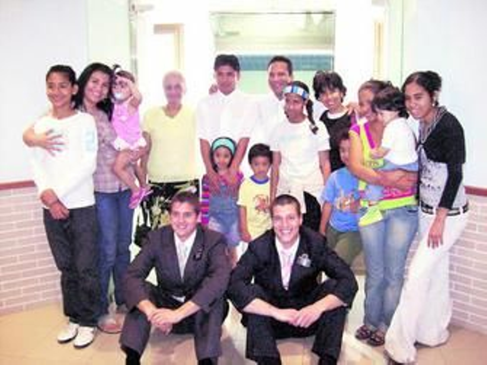 Dos misioneros mormones junto a un recién bautizado y su familia. Dos misioneros mormones junto a un recién bautizado y su familia.