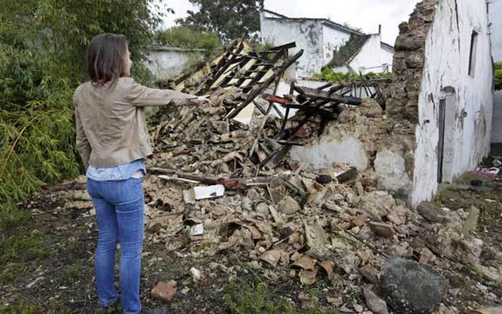 Rocío señala la construcción derrumbada por el seísmo en su huerta, situada a la salida de la localidad. El techo pudo caerle encima en la tarde del martes. /Fito Carreto