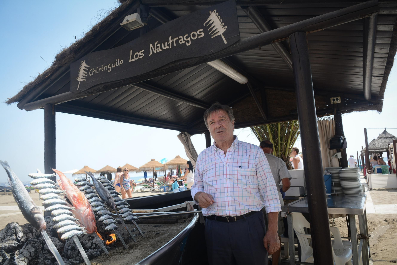 Norberto del Castillo, junto a la barca donde se asan los espetos para su restaurante, en el paseo de Los Boliches de Fuengirola.