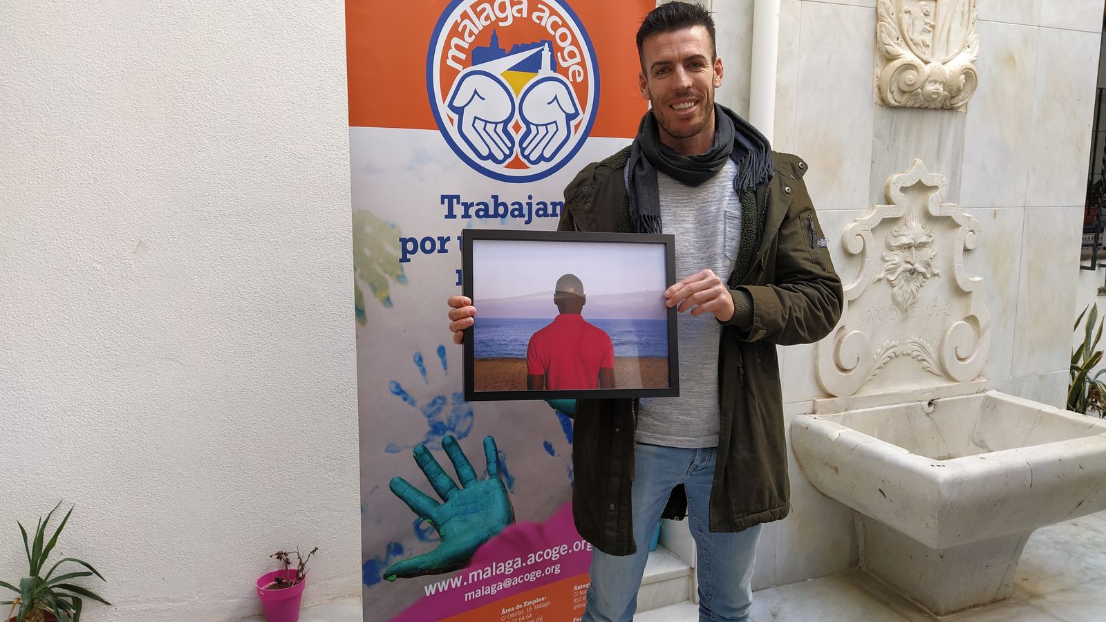 Miguel Roldán posa con su reconocimiento en la sede de Málaga Acoge