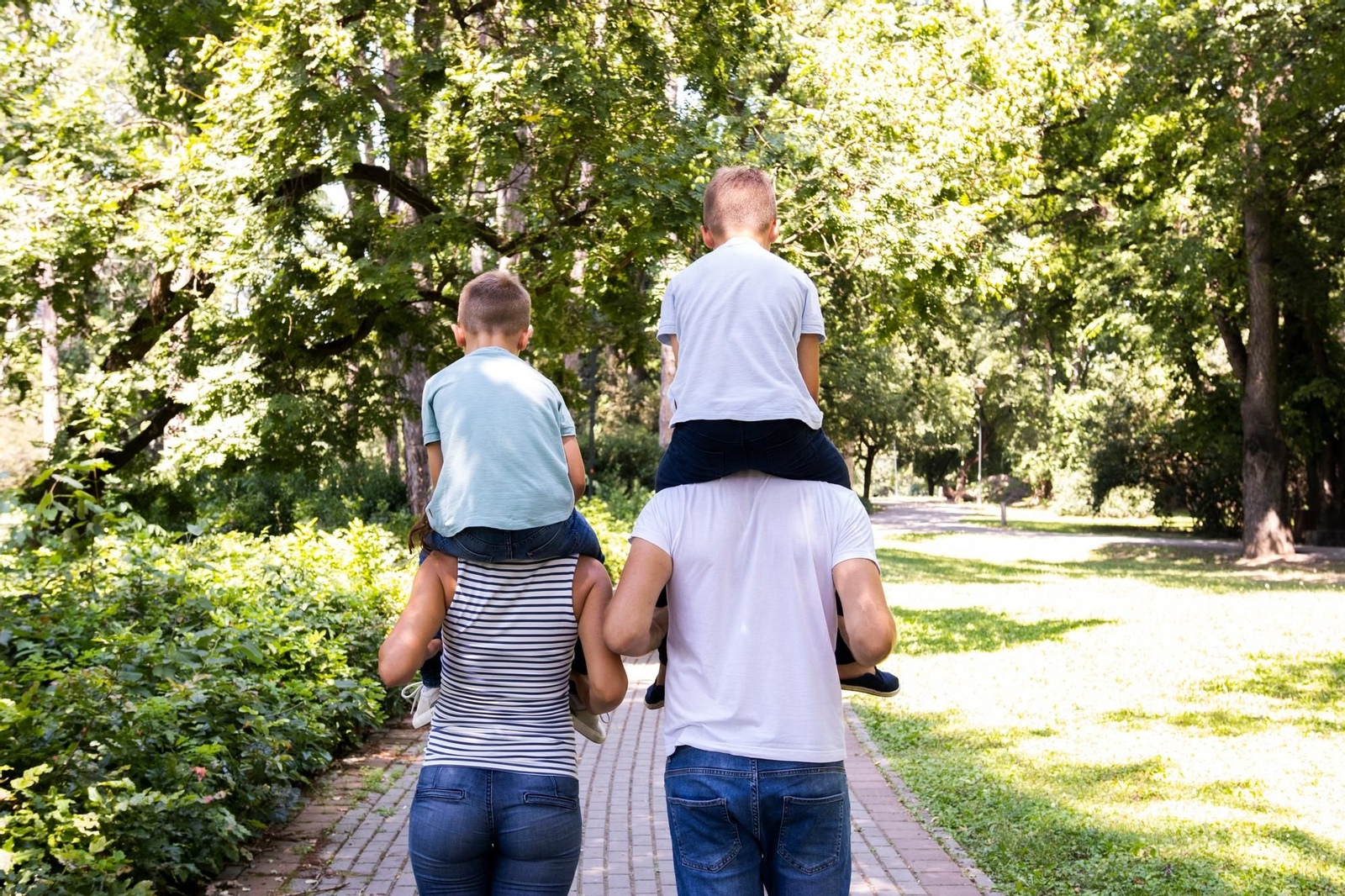 Padres cargando a sus hijos sobre los hombros.
