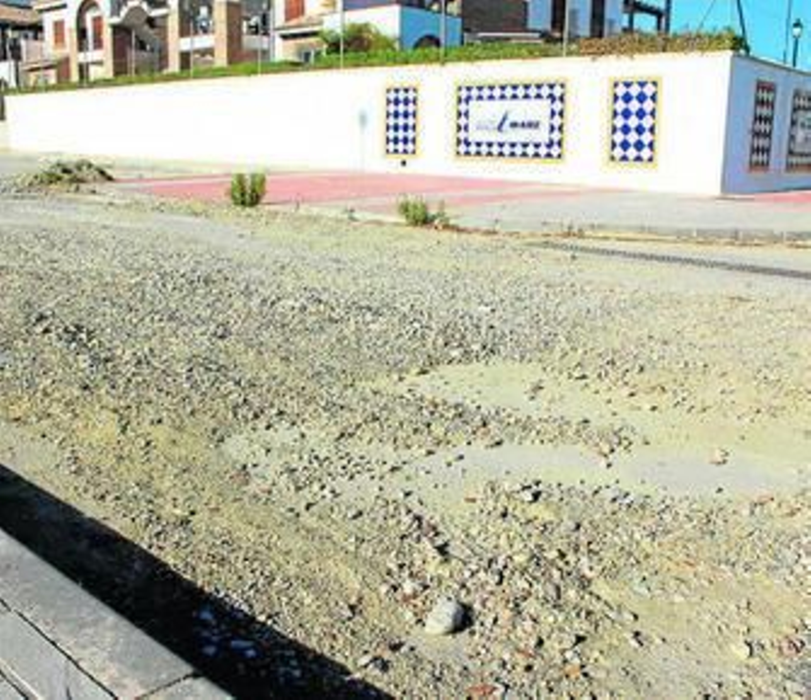 Avenida Cañada Julián llena de guijarros varios meses tras las lluvias de septiembre.