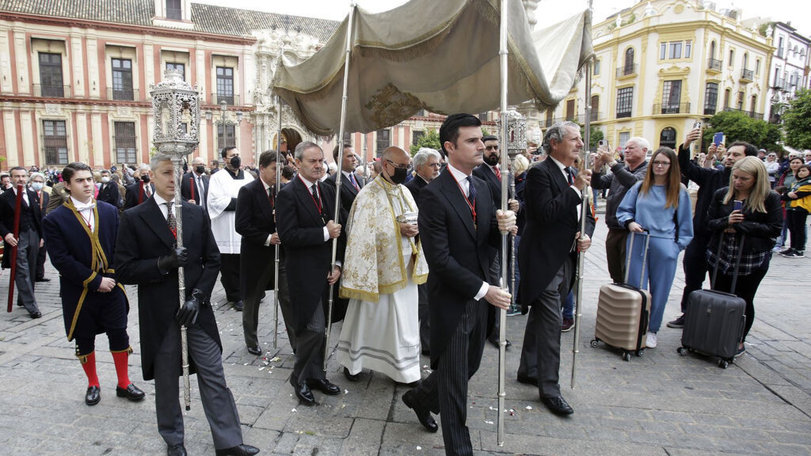 El párroco porta entre sus manos la Divina Majestad, que será repartida a los fieles impedidos