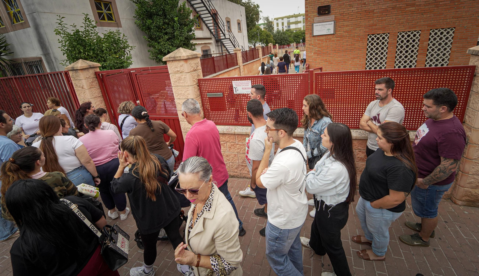 Padres y familiares de alumnos del Centro Infantil La Granja recogiendo a los niños al mediodía, este martes.