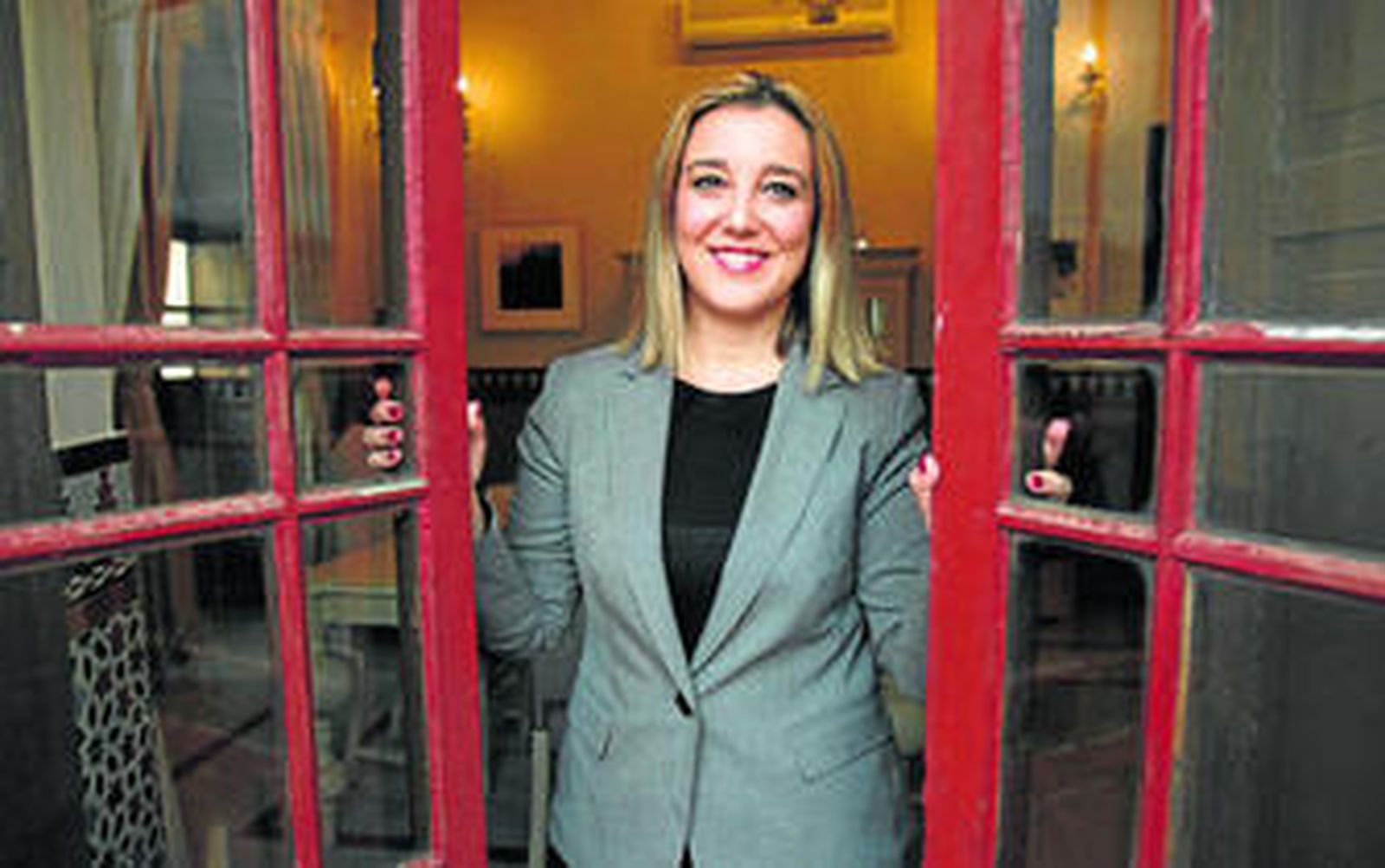 Ana Isabel Jiménez abriendo una ventana del Ayuntamiento de Alcalá de Guadaíra.
