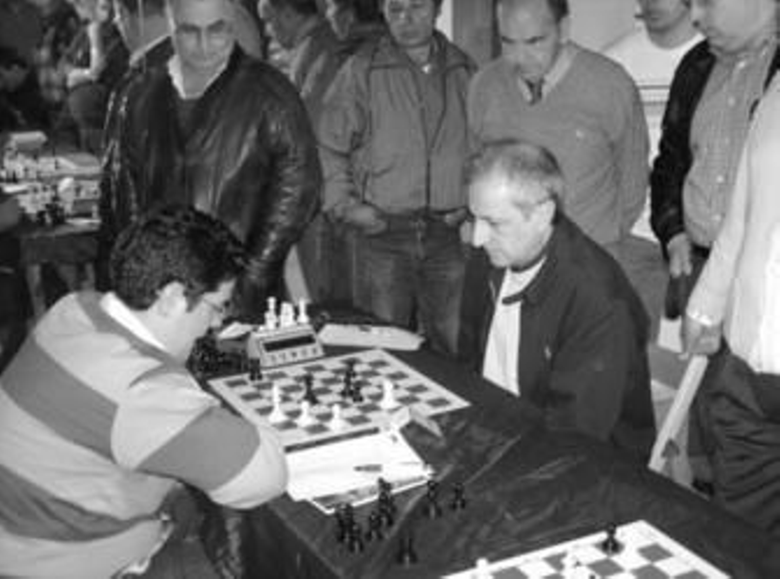 Alfonso Carlos Gómez Rebollo (derecha) en su partida contra Angel Mariano Rodríguez, junto a aficionados.