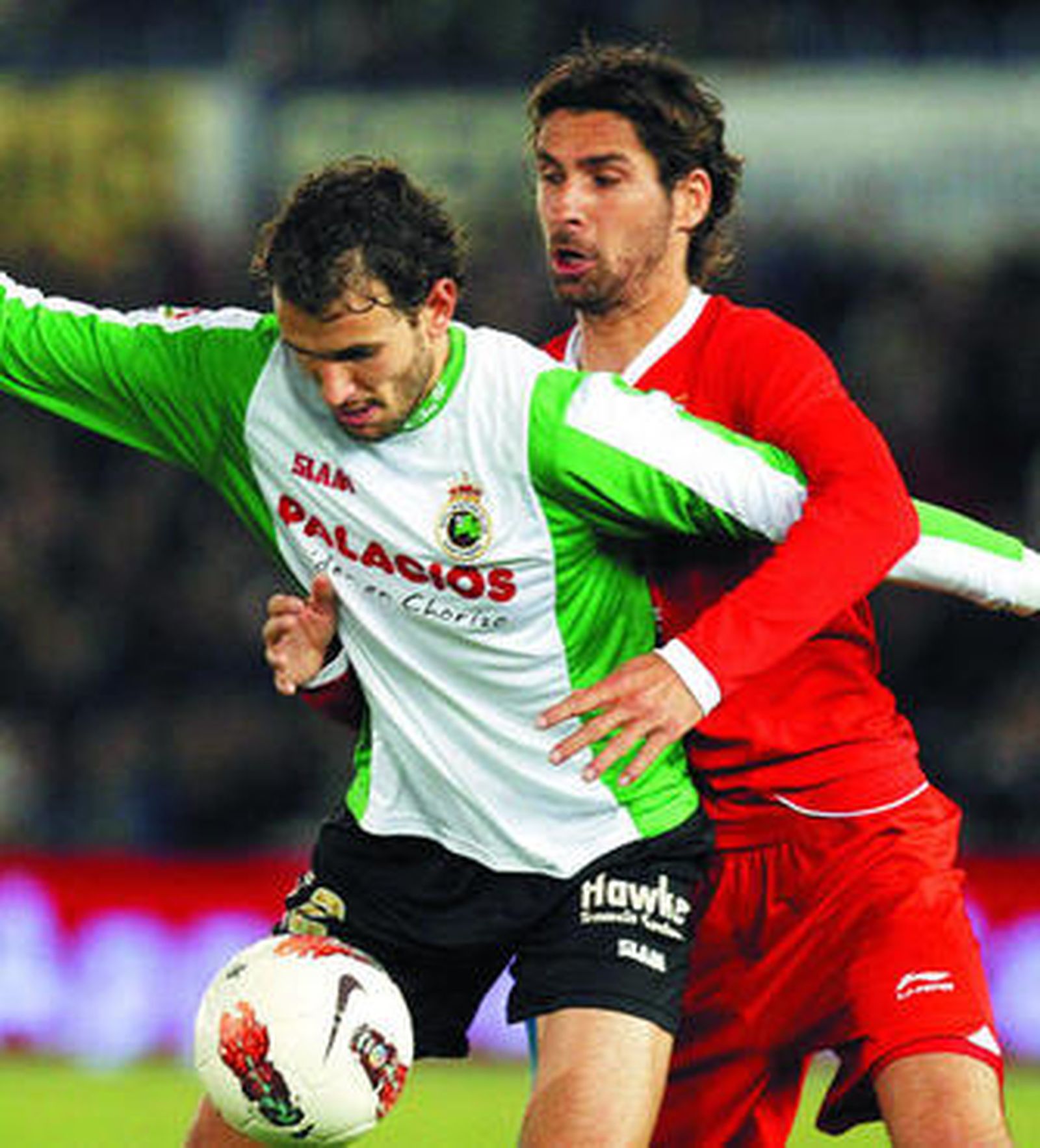 Stuani controla el esférico presionado por el sevillista Escudé.