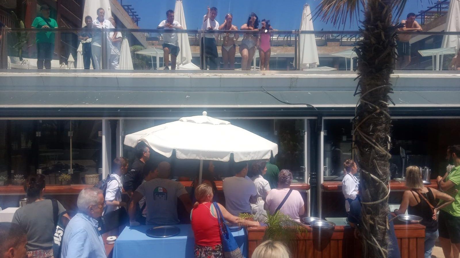 Varios turistas alojados en el hotel contemplan la cacerolada.